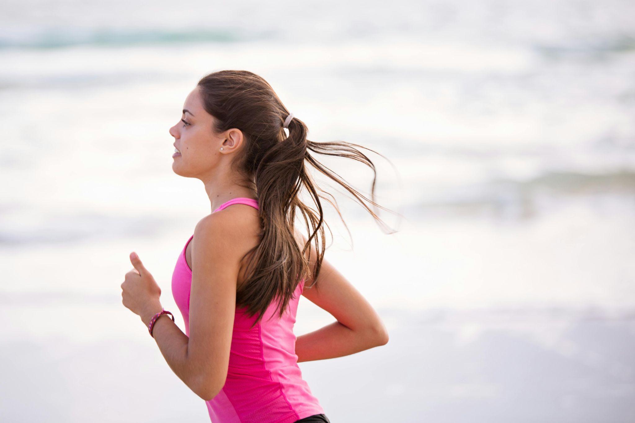 Close-up of woman running on the beach.